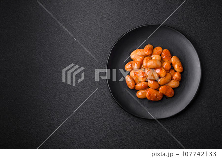 Delicious canned beans in a tomato in a round ceramic plate 107742133