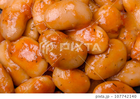 Delicious canned beans in a tomato in a round ceramic plate Delicious canned beans in a tomato in a round ceramic plate 107742140