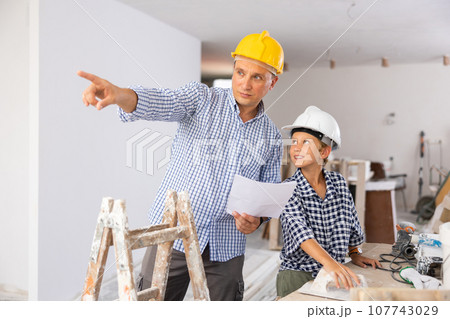 Father and son talking about space planning in new apartment 107743029