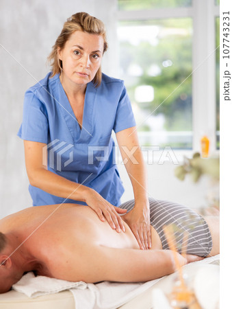 massage therapist doing a body massage 107743231