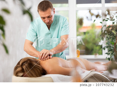 The masseur makes a massage to woman 107743232
