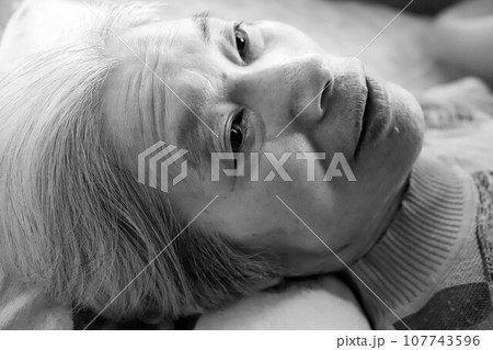 介護ベッドで横になって休む高齢のシニア女性 107743596