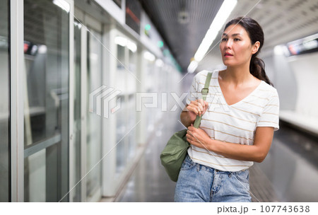 Woman waiting for train in subway station 107743638