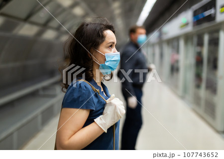 Brunette in medical mask waiting for subway train 107743652