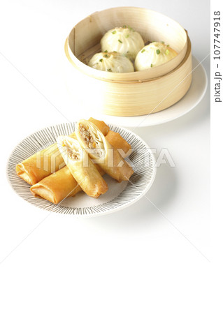 揚げ春巻きと蒸籠に入っている熱々小籠包 揚げ春巻きと蒸籠に入っている熱々小籠包 107747918