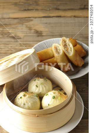 蒸籠に入っている熱々小籠包と揚げ春巻き 107748054
