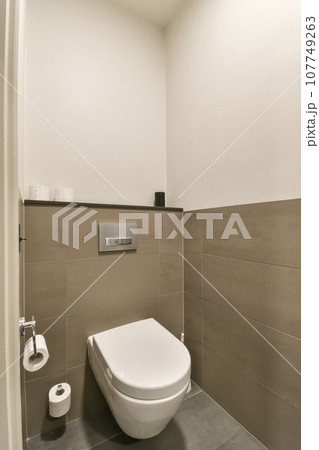 a toilet in the corner of a bathroom with tile on the floor and walls, it's all white a toilet in the corner of a bathroom with tile on the floor and walls, it's all white 107749263