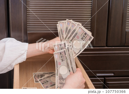 【主婦がたんすの引き出しに一万円札を隠す】 107750366