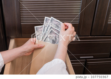 【主婦がたんすの引き出しに封筒入りの一万円札を隠す】 【主婦がたんすの引き出しに封筒入りの一万円札を隠す】 107750367