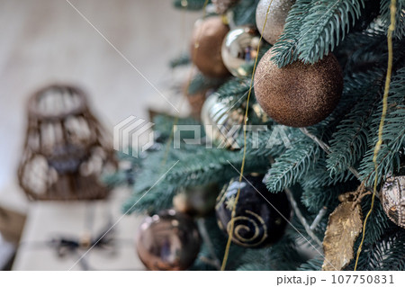 Multicolored Christmas tree decorations, close-up of a Christmas tree with garlands and glass balls. Multicolored Christmas tree decorations, close-up of a Christmas tree with garlands and glass balls. 107750831