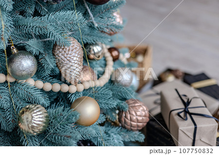 Multicolored Christmas tree decorations, close-up of a Christmas tree with garlands and glass balls. Multicolored Christmas tree decorations, close-up of a Christmas tree with garlands and glass balls. 107750832