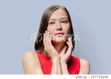 Young woman with natural makeup, with trendy nose piercing jewelry on gray background Young woman with natural makeup, with trendy nose piercing jewelry on gray background 107750894