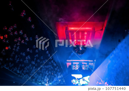 An element of the modern interior of a nightclub, a ceiling with light bulbs in neon light and a disco ball 107751440