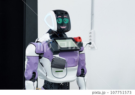 friendly humanoid robot guide expressing emotions is charging from a socket friendly humanoid robot guide expressing emotions is charging from a socket 107751573