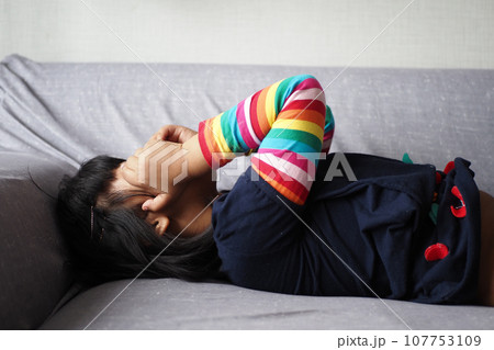 a upset child girl cover her face with hand  107753109