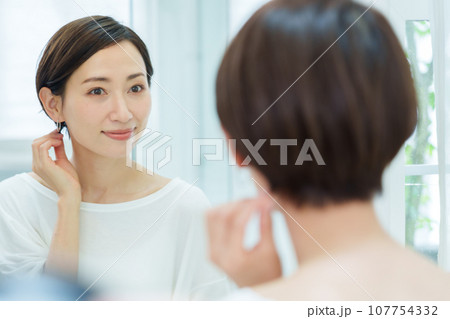 メイクルームでピアスを付ける女性 メイクルームでピアスを付ける女性 107754332