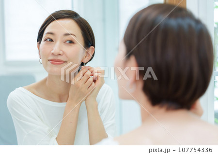 メイクルームでピアスを付ける女性 107754336