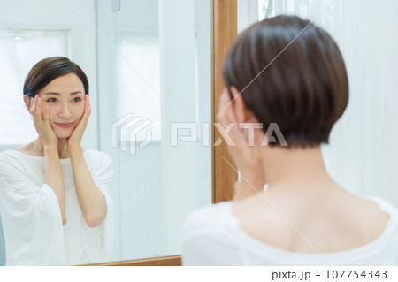 メイクルームでお肌をチェックする女性 メイクルームでお肌をチェックする女性 107754343