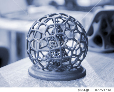 Abstract model Christmas tree in mesh ball printed on 3D printer from polyamide powder close-up. Technology Multi Jet Fusion, MJF. Three-dimensional model created on 3D printer from powder plastic 107754748