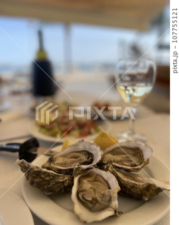 Fresh oysters and white wine on a wooden table, Algarve, Portugal Fresh oysters and white wine on a wooden table, Algarve, Portugal 107755121