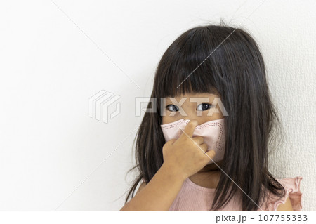 マスクを外そうとしている女の子（3歳、日本人） 107755333