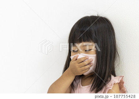マスクをして口を押さえる女の子（3歳、日本人） 107755428