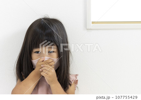 マスクをして口を押さえる女の子(3歳、日本人) マスクをして口を押さえる女の子(3歳、日本人) 107755429