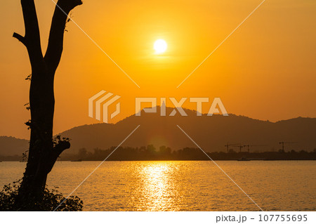 scenery yellow sky glare of sun above Phuket big Buddha.Phuket Big Buddha is one of the island most important and revered landmarks on the island..image for travel and culture concept. 107755695