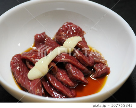 おろしにんにくを乗せてタレをかけた赤身の馬刺し 107755843