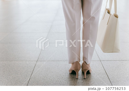 パンプス・ハイヒールを履いて歩く女性・ビジネスウーマンの後ろ姿（通勤・出勤・進む・進歩・チャレンジ） 107756253