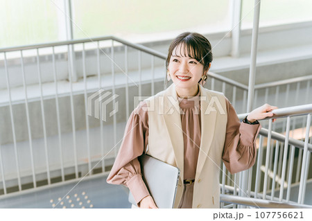 オフィスの階段を登る女性・ビジネスウーマン（朝・出社・通勤） 107756621