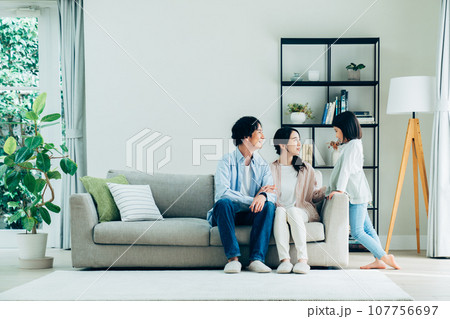 リビングでくつろぐ若い家族 リビングでくつろぐ若い家族 107756697