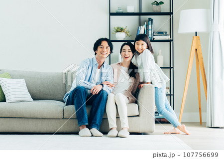 リビングでくつろぐ若い家族 107756699