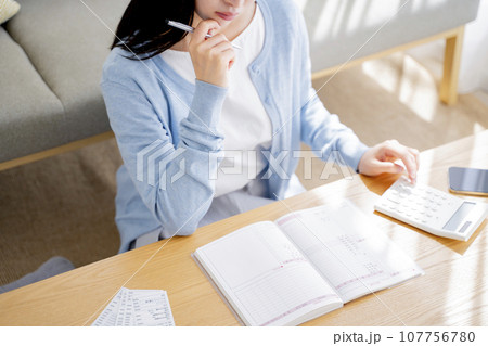 家計簿をつける女性 107756780