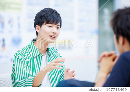 友達と話をする大学生 107758460