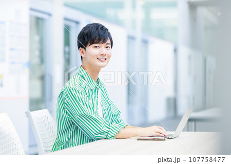 パソコンを使う大学生 107758477