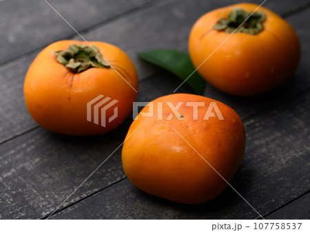 とっても甘い秋の味覚 柿 フルーツ （古板黒バック）柿の実 かき 果物 107758537