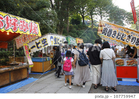 縁日の露店の写真。溢れる程の人々が縁日の露天に集まった。祭り囃子の中を楽しそうに食べ歩く 縁日の露店の写真。溢れる程の人々が縁日の露天に集まった。祭り囃子の中を楽しそうに食べ歩く 107759947