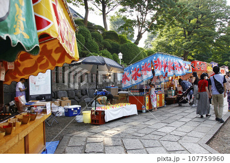縁日の写真。露店が並ぶ参道は、何時もは静寂の石畳も縁日の露店に彩られて賑やか 107759960