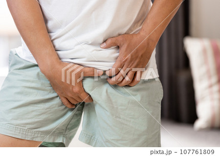 Concept of Prostatitis,Penis Cancer,Testicular Tumor,middle aged man holding his crotch,problem of genitourinary,asian male patient with Prostate cancer,Penile Carcinoma,malignant tumor,illness health 107761809