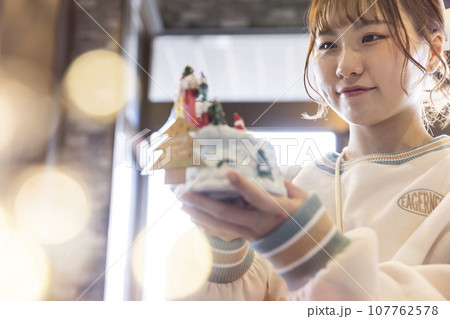 雑貨屋さんでクリスマスプレゼントを選ぶ若い女性 雑貨屋さんでクリスマスプレゼントを選ぶ若い女性 107762578