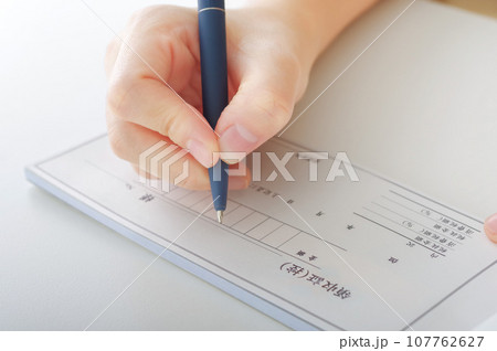 領収書を書く女性の手元 107762627