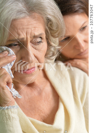 Portrait of sad Senior woman with daughter at home 107763047
