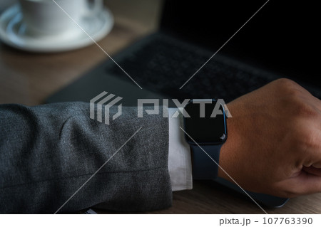 Man checking time on his smartwatch device Close-up display clock checking lifestyle communication phone mobile touch app technology 107763390