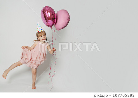Happy kid with pink balloon on white studio wall banner background Happy kid with pink balloon on white studio wall banner background 107765595