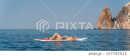 Sports girl on a board for glanders surfing in the sea 107765823
