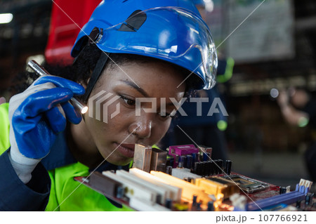 Female african american professional technician checking computer motherboard.  107766921