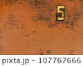 Old metal painted texture. Red painted background . Painted surface with rust. The plate with the number 5 on a rusty metal wall. Old uneven iron surface. Perfect for grunge design. 107767666