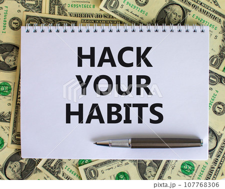 Hack your habits symbol. Words 'Hack your habits' on white note. Beautiful background from dollar bills, metallic pen. Business, psychology and hack your habits concept. Copy space. 107768306