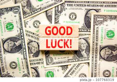 Good luck symbol. Concept words Good luck on beautiful wooden block. Beautiful background from dollar bills. Dollar bills. Business, motivational good luck concept. Copy space. 107768319